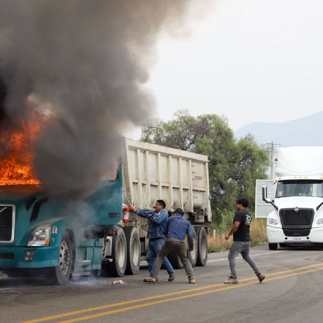 Al retirarse del bloqueo que mantenían sobre la carretera 190 en inmediaciones de la Villa de Mitla, profesores de la CNTE apedrearon e incendiaron un vehículo que presuntamente habría participado en el desalojo que sufrieron horas antes. (27 de mayo 2026. Foto: Cuartoscuro